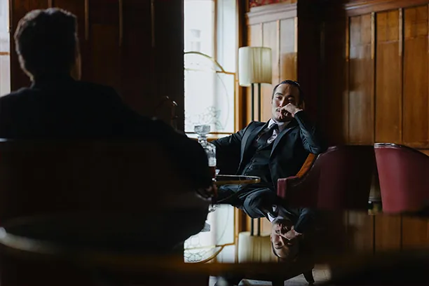 Two executives in conversation in a private, wood-panelled room